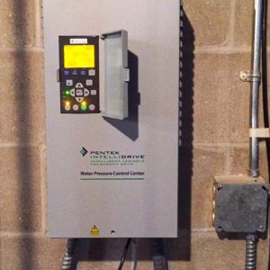Pentek Intellidrive water preserve control center hanging on brick wall.