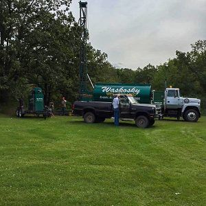 green waskosky well drilling vehicle in a backyard