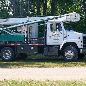 Waskosky Well Drilling white and green truck with drilling equipment.